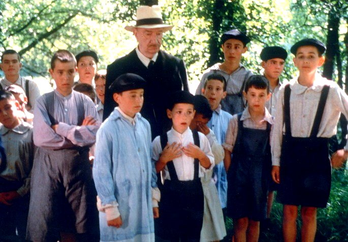 Una escena de la película La lengua de las hormigas que muestra a un grupo de niños con una maestra anciana.