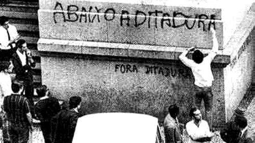 Grafiti en una pared donde se puede leer la dictadura debajo