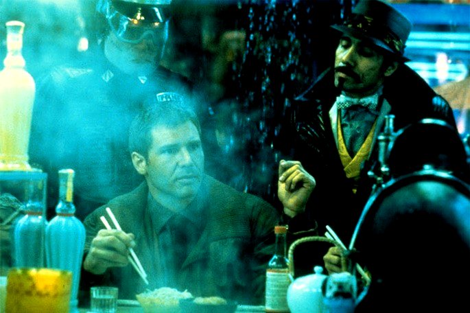 Una escena de Blade Runner en tonos azules donde Deckard está comiendo fideos en la calle y los oficiales entran para arrestarlo.