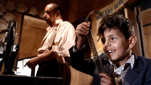 Una escena de la película Cinema Paradiso muestra a un niño mirando negativos de cine.