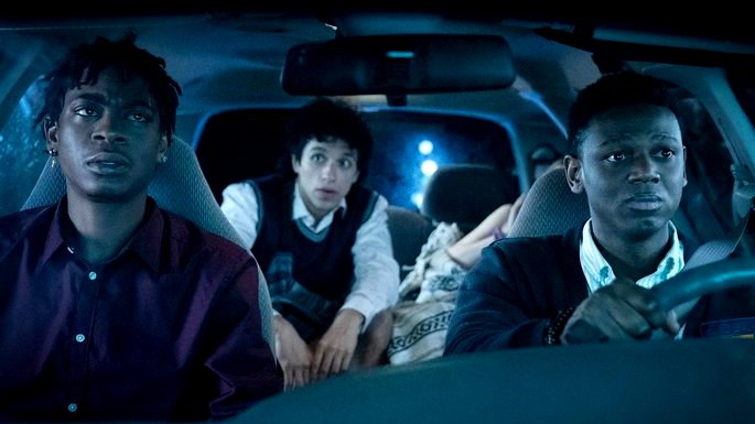 Tres adolescentes en un auto, con expresión preocupada.