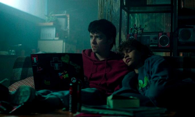 unos adolescentes, sentados en el sofá, con la computadora frente a ellos.
