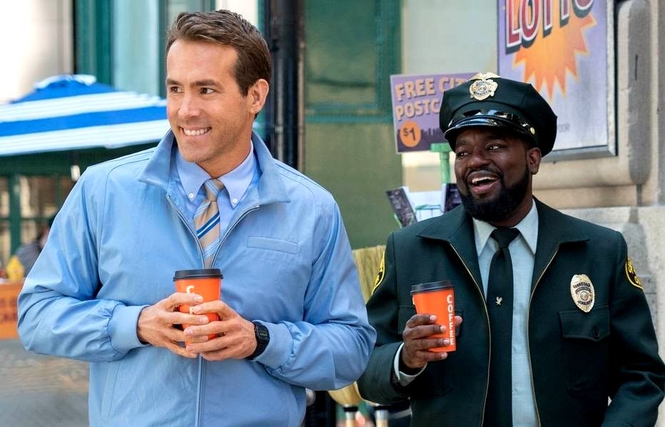 Una escena de la película Free Guy muestra a un hombre blanco y un policía negro caminando por la calle.