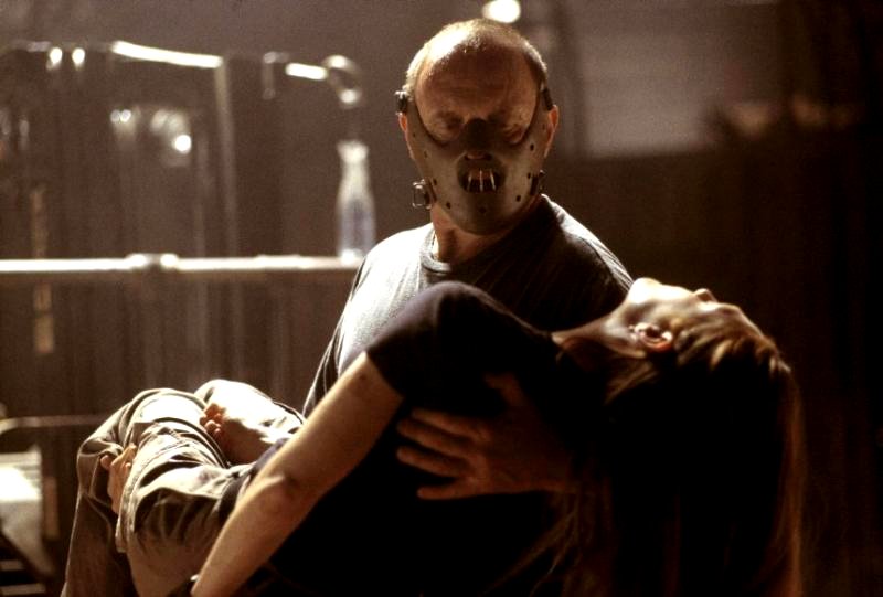 Una escena de la película Hannibal muestra a un hombre enmascarado con una mujer en su regazo.