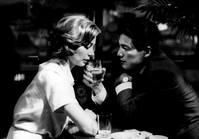 Fotografía en blanco y negro de una pareja en un bar, bebiendo cerveza, cara a cara