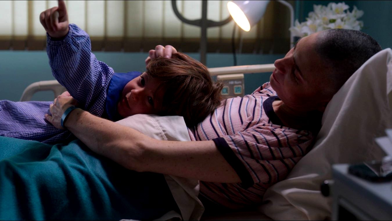 Una escena de Tomy's Notebook muestra a una mujer y su bebé en una cama de hospital.
