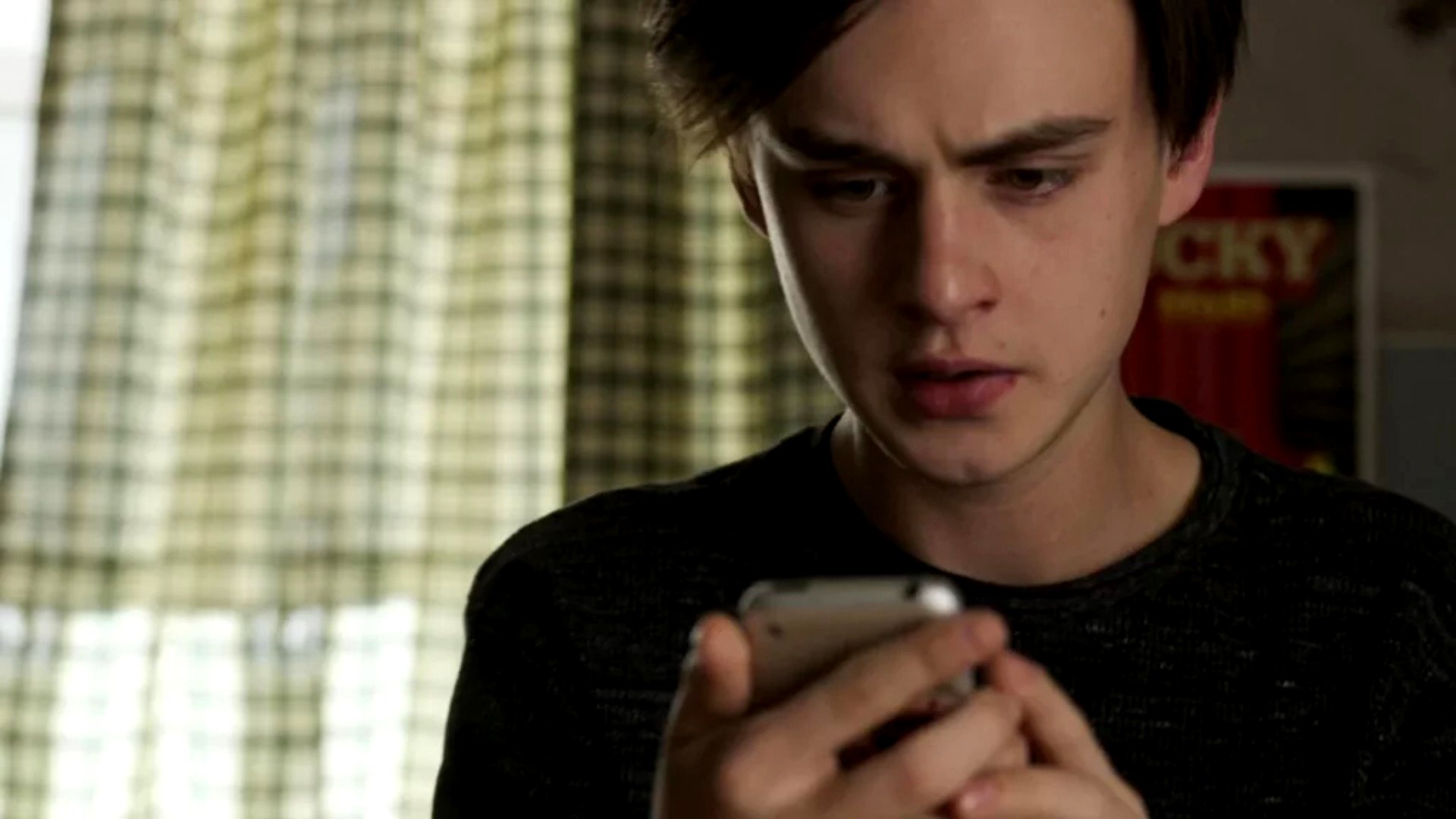 una escena de la película Mr Harrington's Phone muestra a un joven mirando un teléfono móvil