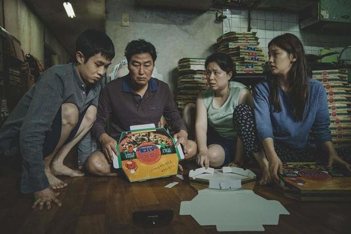 Una familia trabajando en su casa, haciendo cajas de pizza.