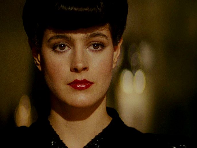 El personaje Racheal en Blade Runner está sobre un fondo amarillo y muestra su cabello y ojos rojos.