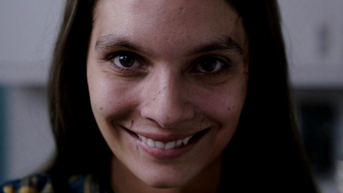 Mujer sonriendo con una expresión de miedo